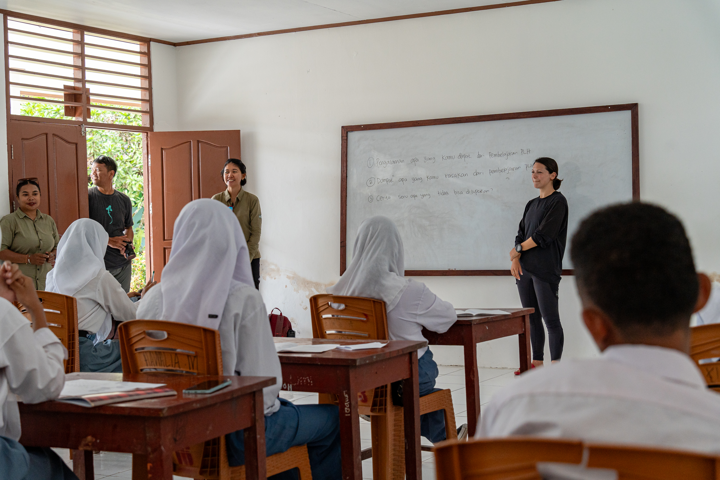 Andi Cross leading marine conservation education session in classroom with local students in Misool, Indonesia