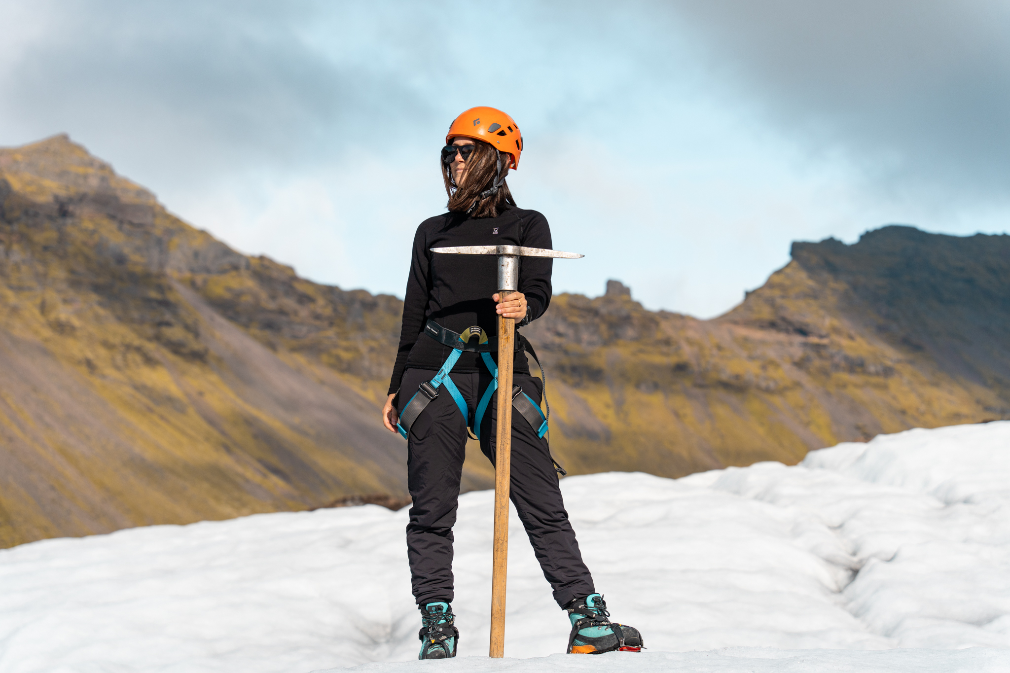 Andi Cross on glacier expedition in Iceland, Arctic Adventures, wearing orange helmet and holding ice axe